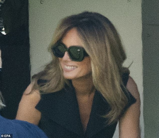 Melania is seen wearing large sunglasses and a broad smile that some Twitter users believe did not match her usual subtle grin
